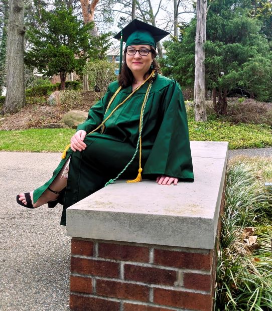 Me in cap and gown on graduation day, celebrating academic success and personal healing from CPTSD.